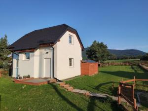 ein kleines weißes Haus auf einem Grasfeld in der Unterkunft Domek w Białej - Mak in Marcinowice