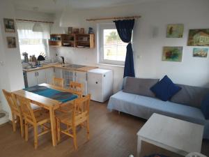 a kitchen and living room with a table and a couch at Domek w Białej - Mak in Marcinowice