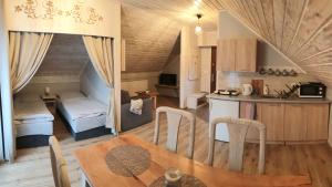 a kitchen and living room with a table and a dining room at Słoneczna Hytte in Brenna
