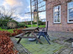 a picnic table and a bench in front of a building at Landelijk gelegen vakantiestudio ME02 in Meliskerke