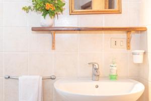 a bathroom with a sink and a mirror and flowers at Casa Pasqualina in San Giovanni +18 photos
