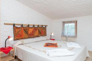 a white bedroom with a bed with a red table at Casa Pasqualina in San Giovanni