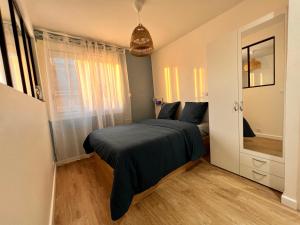 um quarto com uma cama com um cobertor azul em Appartements calmes - Standing - Hypercentre - CLIM - WIFI - Netflix em Montpellier