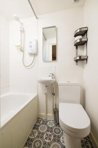 La salle de bains est pourvue de toilettes, d'un lavabo et d'une baignoire. dans l'établissement Charmstay King's Cross, à Londres