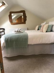 a bedroom with two beds and a mirror at Swallows Nest in Bradwell +18 photos