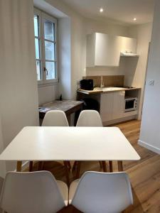 una cucina con tavolo e sedie in una stanza di Lamballe plein centre, superbe appartement 1er étage a Lamballe