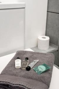 a bathroom with a towel on a counter with toiletries at Penarth/Cardiff Bay: Deluxe Flat: 10 Mins to City! in Cardiff