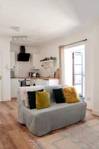 a living room with a gray couch with yellow pillows at Penarth/Cardiff Bay: Deluxe Flat: 10 Mins to City! in Cardiff