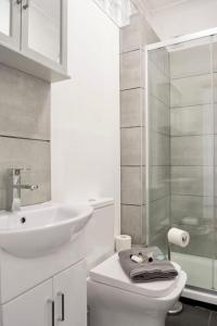 y baño con aseo, lavabo y ducha. en Penarth/Cardiff Bay: Deluxe Flat: 10 Mins to City!, en Cardiff