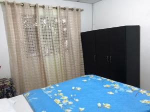 1 dormitorio con 1 cama con sábanas y cortinas azules en Apartamento Cómodo, en Ríohacha