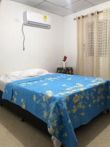 1 dormitorio con 1 cama con manta azul en Apartamento Cómodo, en Ríohacha