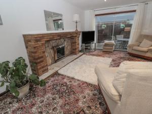 a living room with a couch and a fireplace at Garden House in Wooler