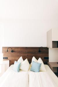 1 dormitorio con cama blanca y almohadas azules en Villa Blumegg en Hermagor