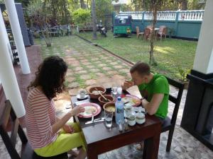 Un uomo e una donna seduti a tavola mangiando cibo di Miyonra - Anuradhapura a Anuradhapura