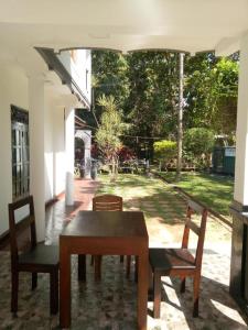 a table and chairs in a room with a yard at Miyonra - Anuradhapura in Anuradhapura