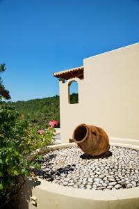 a vase sitting on the ground next to a building at Alonissos Beach Bungalows And Suites Hotel in Alonnisos