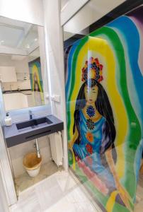 a bathroom with a painting of a woman on the wall at Suite Bali in Seville