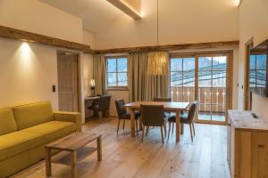 Una sala de estar con un sofá, una mesa y sillas. en Huber unterm Baum, en Lagundo