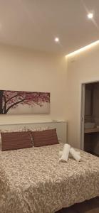 uma cama com duas almofadas e um quadro na parede em La Quinta Hacienda em Córdoba