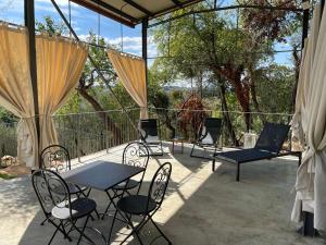 une terrasse avec une table et des chaises et quelques arbres dans l'établissement Oliveta del Verde Appartamento con Grande Giardino 500mt dal Centro, à Sienne