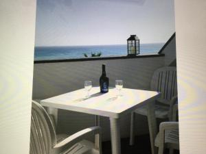 a white table with a bottle of wine and two glasses at Leme Bedje GST84 3 bedroom apt with Panaramic views in Santa Maria