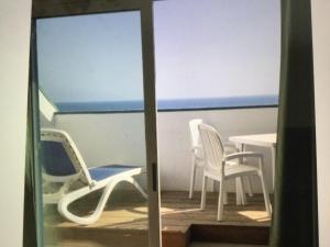 a balcony with chairs and a table and the ocean at Leme Bedje GST84 3 bedroom apt with Panaramic views in Santa Maria