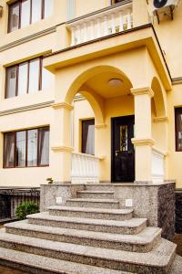 a yellow building with stairs in front of a door at Phazisi Hotel in Tbilisi City