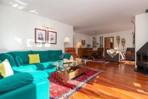 uma sala de estar com um sofá azul em Apartament Terrasses F em El Tarter