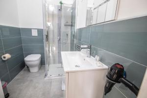 uma casa de banho com um lavatório, um chuveiro e um WC. em Piano Monaco Apartment em Carini