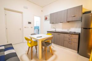 uma cozinha com uma pequena mesa e cadeiras amarelas em Piano Monaco Apartment em Carini