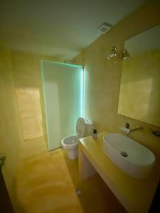 a bathroom with a sink and a toilet and a mirror at ElGreco By the sea in Nea Karvali