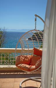 a couch sitting on top of a wooden bench in front of the ocean at Alonissos Beach Bungalows And Suites Hotel in Alonnisos