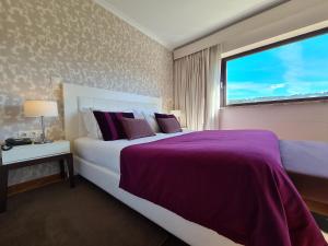 ein Schlafzimmer mit einem großen Bett und einem Fenster in der Unterkunft Quinta de Santo Estêvão Hotel Rural in Aguiar da Beira