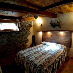 a bedroom with a bed and a stone wall at CleMaison Antica Dimora Apartments CIR VDA GIGNOD 0013 in Gignod