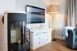 a living room with a fireplace and a flat screen tv at Suite Salzluft mit Sauna in Zingst