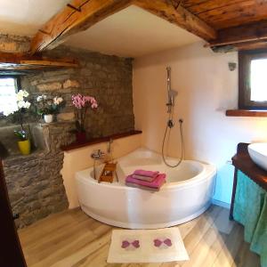 a bathroom with a bath tub and a sink at CleMaison Antica Dimora Apartments CIR VDA GIGNOD 0013 in Gignod +77 photos