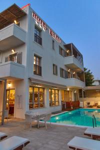 a hotel with a swimming pool in front of a building at Erato Hotel in Agia Marina Aegina