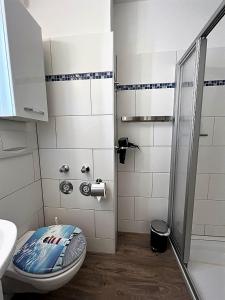 een badkamer met een toilet, een wastafel en een douche bij Duhner Strandliebe in Cuxhaven