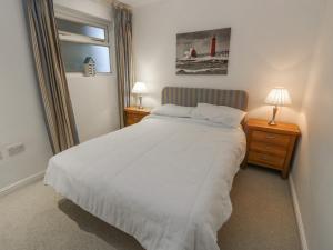 a bedroom with a white bed and two night stands at Pierpont D1 in Yarmouth