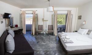 a bedroom with a large bed and a living room at Erato Hotel in Agia Marina Aegina