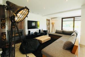 - un salon avec un canapé et une télévision dans l'établissement Beautiful Algarve Pool Villa Bali 15min to beach, à Mexilhoeira Grande
