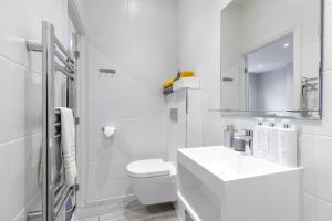 een witte badkamer met een wastafel en een toilet bij CitySpace Leicester Square in Londen