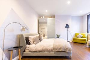 1 dormitorio con 1 cama y 1 silla amarilla en CitySpace Leicester Square, en Londres