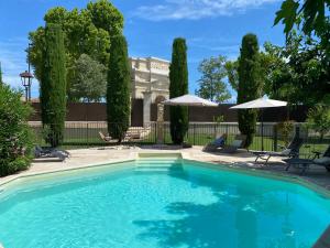 a swimming pool in a yard with umbrellas at Villa Agrippa in Orange