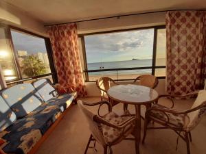 1 dormitorio con 1 cama, mesa y sillas en Torre Levante-Fincas Benidorm, en Benidorm