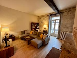 sala de estar con sofá y mesa en Maison de caractère dans la bastide foyenne, en Sainte-Foy-la-Grande