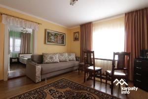 una sala de estar con un sofá y una silla en Садиба "Барвінок", en Podobovets