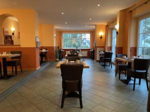 a restaurant with tables and chairs and windows at Villa Strandkorb in Graal-Müritz