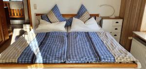 a bed with blue and white sheets and pillows at Ferienwohnung Ott Schongau in Schongau