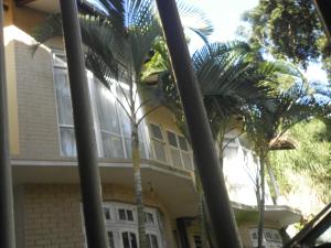 una casa con palmeras delante en McCarthy Guesthouse, en Kandy